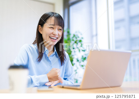 手を打つ 納得する女性 リビングでテレワークをする若い女性の写真素材 [125795871] - PIXTA