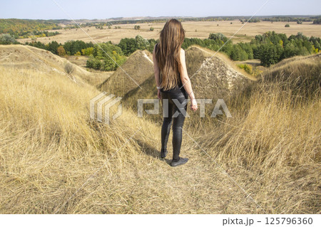 Beautiful strong dark haired woman in black clothes outdoor in the nature enjoy with freedom Beautiful strong dark haired woman in black clothes outdoor in the nature enjoy with freedom 125796360