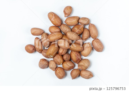 Raw brown peanuts macro view from above on white background Raw brown peanuts macro view from above on white background 125796753