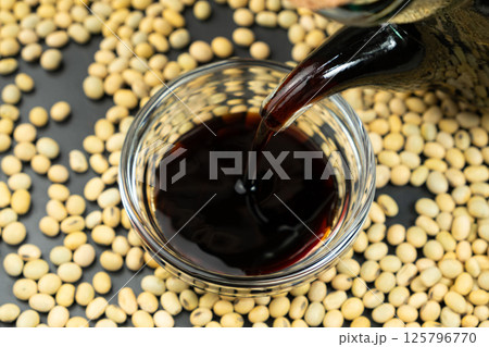 Close-up of the process of pouring soy sauce into a saucepan. Close-up of the process of pouring soy sauce into a saucepan. 125796770