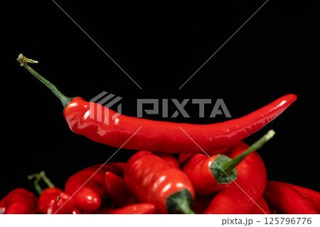 Fresh Red Chili Peppers on Black Background Fresh Red Chili Peppers on Black Background 125796776