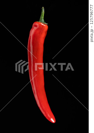 One hot red chili pepper on a black background close-up. 125796777