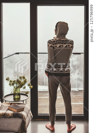 Man Enjoying Winter Scenery outside Window Man Enjoying Winter Scenery outside Window 125796999