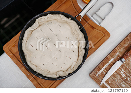 Unbaked rustic fruit galette is preparing outdoors. Unbaked rustic fruit galette is preparing outdoors. 125797130
