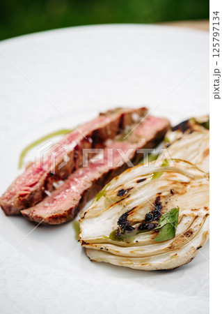 Gourmet outdoor meal of juicy steak and grilled vegetables. 125797134