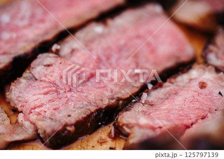 Sliced grilled steak on wooden cutting board. Sliced grilled steak on wooden cutting board. 125797139
