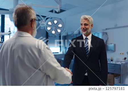 Portrait of pharmaceutical sales representative shaking hand with doctor. 125797181