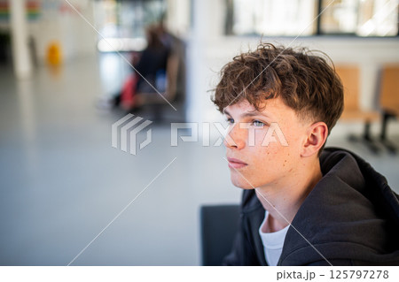 Teenage boy waiting alone in hospital waiting area before medical checkup. 125797278
