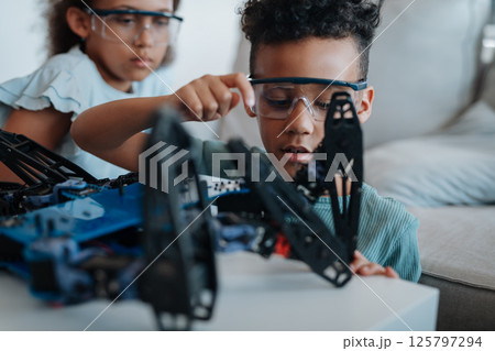 Kids building their first homemade robot at home. Kids building their first homemade robot at home. 125797294