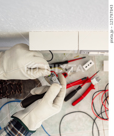 Electrician at work on a residential electrical system. Electricity. 125797843