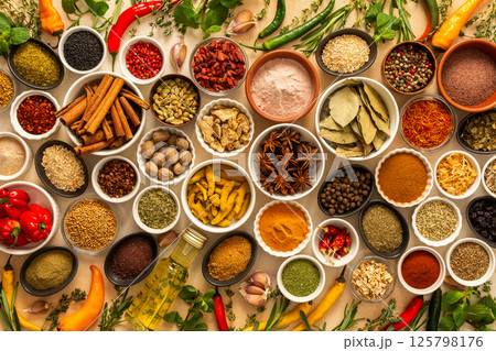 Diverse selection of cooking spices and dried herbs on a beige background, showcasing natural textures and colors that enhance culinary experiences Diverse selection of cooking spices and dried herbs on a beige background, showcasing natural textures and colors that enhance culinary experiences 125798176