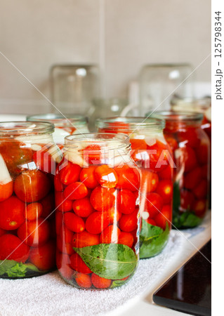 Preserving fresh tomatoes and tomato juice for the winter, stored in airtight jars for long-term use 125798344