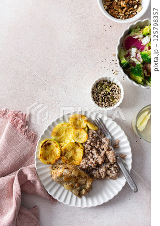 A nutritious, balanced breakfast featuring green buckwheat, fried hake, zucchini, and a fresh broccoli salad with pink radish, seeds, and nuts, offering a wholesome start to the day A nutritious, balanced breakfast featuring green buckwheat, fried hake, zucchini, and a fresh broccoli salad with pink radish, seeds, and nuts, offering a wholesome start to the day 125798357