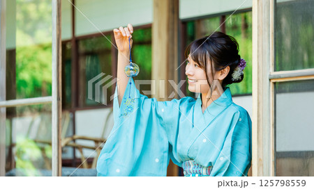 縁側で風鈴を持つ浴衣姿の日本人女性 縁側で風鈴を持つ浴衣姿の日本人女性 125798559