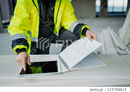 Construction site manager using digital tablet to inspect building progress. Construction site manager using digital tablet to inspect building progress. 125798615