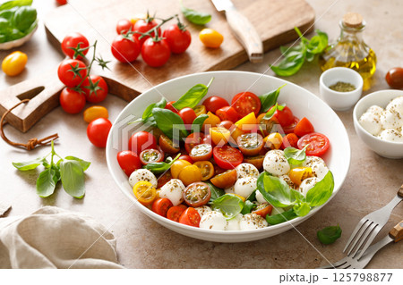Salad with fresh cherry tomatoes, mozzarella and basil leaves 125798877