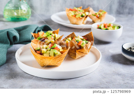 Appetizing cups of guacamole in pita bread on a plate on the table 125798969
