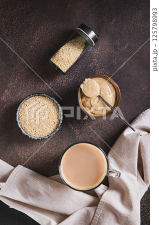 Coffee with sesame paste tahini in a cup on the table top and vertical view Coffee with sesame paste tahini in a cup on the table top and vertical view 125798993
