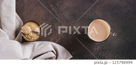 Coffee with sesame paste tahini in a cup on the table top view web banner Coffee with sesame paste tahini in a cup on the table top view web banner 125798994