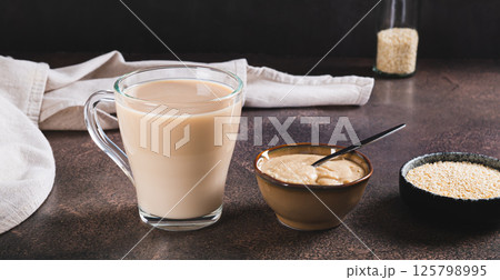 Tahini latte with sesame spread in a cup on the table web banner 125798995