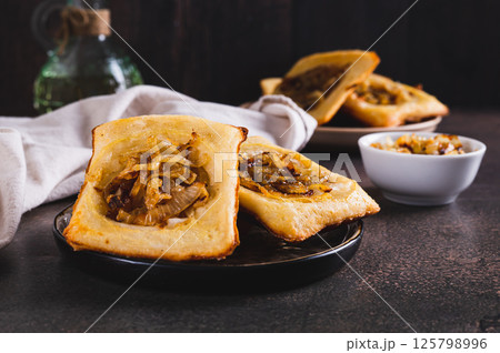 Upside down tarts with caramelized onions on a plate on a table 125798996