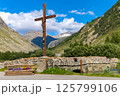 Alpine crucifix overlooking mountain valley in France. 125799106