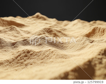 A close up of a sandy surface with small hills under a dark sky in a shallow depth of field 125799919
