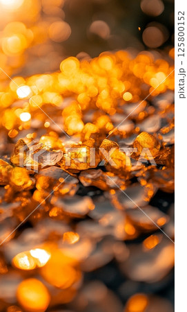 A close up shot of golden stones with bokeh lights in the background creating a warm and inviting scene 125800152