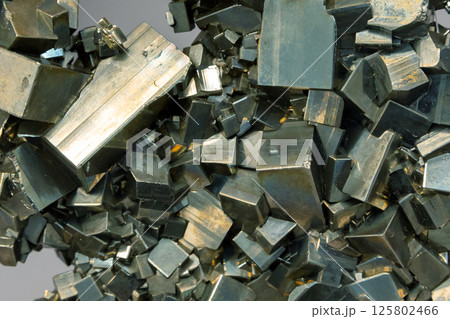 Druse of cubic crystals in golden green tones. The mineral pyrite 125802466
