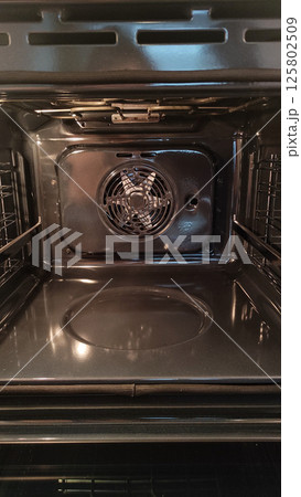 Empty convection oven with fan and racks displaying cooking potential 125802509