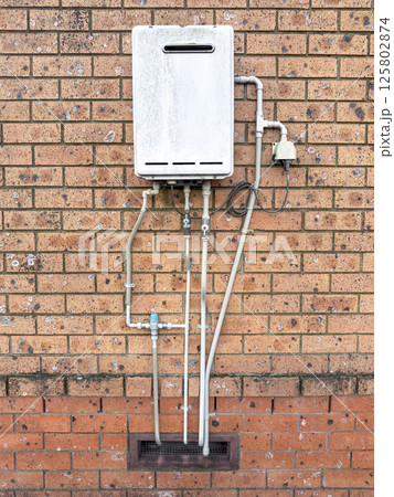 An old hot water service mounted on a wall An old hot water service mounted on a wall 125802874