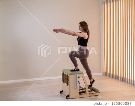 Asian woman doing pilates classic chair.  125803087