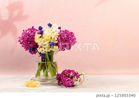Beautiful banner of different varieties of hyacinth and muscari in vase on elegant kitchen background, template for design and screen. Abstract flower arrangement. Spring postcard, 125803340