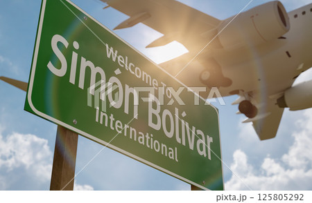 Welcome To Simon Bolivar International Airport Green Road Sign with Low Flying Airplane Just Above with Landing Gear Down. 125805292