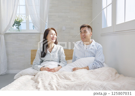 ベットの上の起床した夫婦 125807031