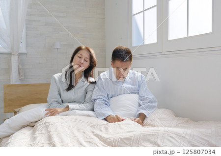 ベットの上の起床した夫婦　倦怠感 125807034