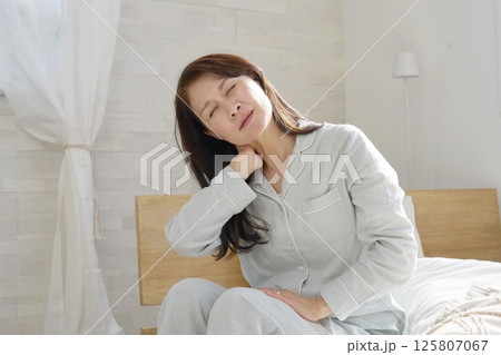 寝違えた中年の女性 125807067