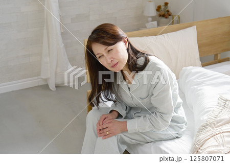膝が痛いパジャマを着た中年の女性 125807071