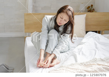 パジャマを着た中年の女性　足のリウマチ　冷え性 125807076