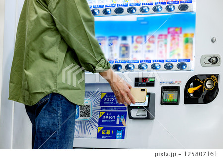 自動販売機でスマホで決済をする男性手元 自動販売機でスマホで決済をする男性手元 125807161