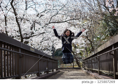 春の桜満開の公園で元気で遊んでいる女子中学生の姿 春の桜満開の公園で元気で遊んでいる女子中学生の姿 125807269