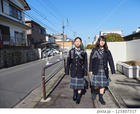 春の朝の住宅地に登校中の姉妹学生の姿 春の朝の住宅地に登校中の姉妹学生の姿 125807317