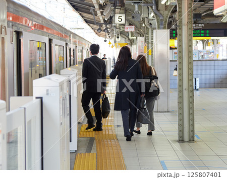 名古屋駅のホームで電車待ちのサラリーマンと人々の姿 名古屋駅のホームで電車待ちのサラリーマンと人々の姿 125807401