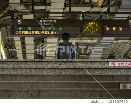 名古屋駅のホームの電車掲示板と男性乗客の姿 125807430