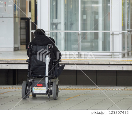 名古屋駅のホームで電車待ちの車椅子に乗る障害者の姿 125807453
