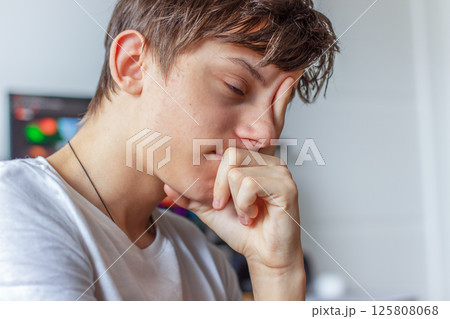 Portrait of a sad tired teenager, the guy supporting his face with his hand, thinking Portrait of a sad tired teenager, the guy supporting his face with his hand, thinking 125808068