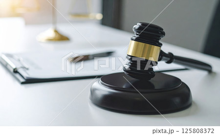 Elegant wooden gavel placed on desk symbolizes justice and court system, representing legal authority and decision making in professional setting 125808372