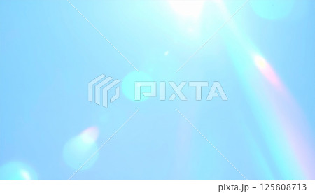 Bright sunlight shines against clear blue sky, creating dreamy atmosphere with glowing light flares and soft sparkles. This serene scene evokes sense of calm and wonder 125808713