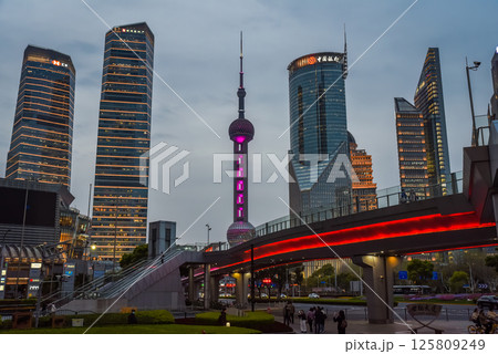 Shanghai, China - 1 April 2025: Night view of Pudong with Oriental Pearl Tower glowing. Bright city lights and illuminated bridges showcase Shanghai's modernity. Shanghai, China - 1 April 2025: Night view of Pudong with Oriental Pearl Tower glowing. Bright city lights and illuminated bridges showcase Shanghai's modernity. 125809249