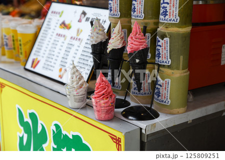 Shanghai, China - 1 April 2025: Colorful soft serve ice cream in black cones and cups on display at a street food stall on Yuyuan Old Street in Shanghai Shanghai, China - 1 April 2025: Colorful soft serve ice cream in black cones and cups on display at a street food stall on Yuyuan Old Street in Shanghai 125809251
